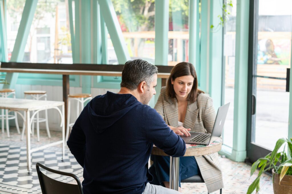 Two salespeople talking face-to-face at a cafe