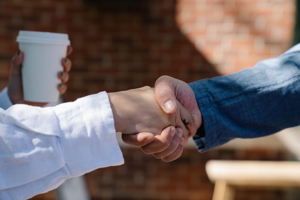 A close up photo of two people shaking hands.